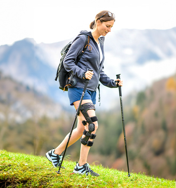 Frau trägt eine Knieorthese beim Wandern